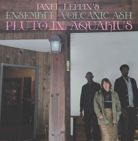 Janel Leppin's Ensemble Volcanic Ash Pluto in Aquarius. Drei Personen stehen vor einer Holzwand.
