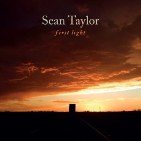 Die Texte "Sean Taylor" und "first light" stehen über einer Straße, die in einen dramatischen Sonnenuntergang führt.