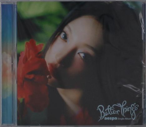 Text: "Better Things - aespa Single Album". 

Frau neben roter Blume, starrt intensiv, Hintergrund unscharf.