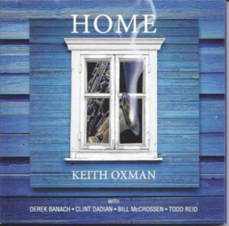 Text: "HOME" von Keith Oxman, mit Derek Banach, Clint Dadian, Bill McCrossen, Todd Reid. 

Blaues Holzhaus, weißes Fenster.