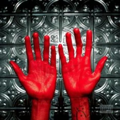 Zwei leuchtend rote Hände sind vor einem kunstvoll verzierten Hintergrund erhoben.