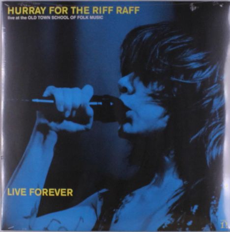 "HURRAY FOR THE RIFF RAFF" und "LIVE FOREVER". Ein*e Sänger*in singt in ein Mikrofon, beleuchtet in blauer Farbe.