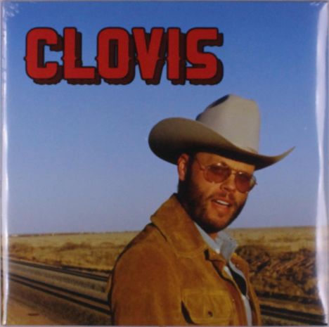 Text "CLOVIS" oben in roten Buchstaben. Ein Mann mit Cowboyhut und Sonnenbrille steht in einer Wüstenlandschaft.