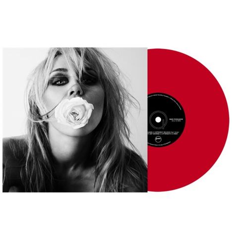 Der Text auf dem Plattenetikett ist nicht vollständig lesbar. Ein Porträt einer Person mit einer weißen Rose im Mund.