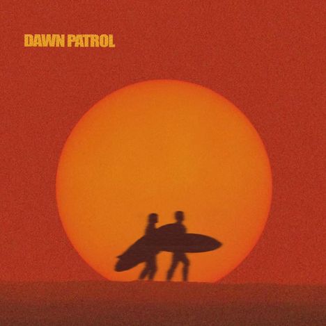 Text: "DAWN PATROL". Zwei Silhouetten mit Surfbrettern vor einer großen untergehenden Sonne auf rotem Hintergrund.