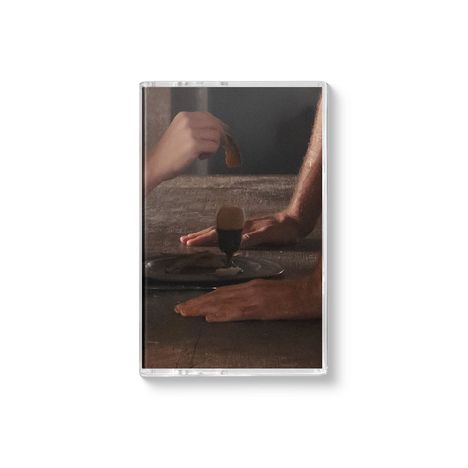 Eine dunkle Tischszene mit Händen, die ein Getränk mit einem Keks in der Hand reichen. Minimalistisches Design.