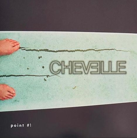 Text: "CHEVELLE", "point #1". Zwei Füße auf einem rissigen grünen Untergrund.