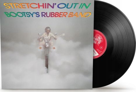 "STRETCHIN' OUT IN BOOTSY'S RUBBER BAND" in bunten Buchstaben. Ein Mann fährt auf einem Motorrad durch Nebel.