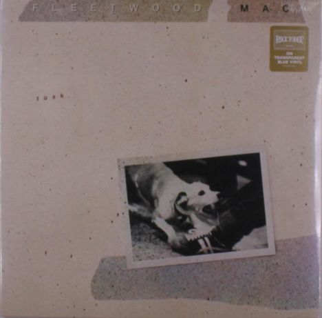 Text: "Fleetwood Mac", "Tusk", "On Transparent Blue Vinyl".  
Ein Hund beißt in einen Schuh auf einem sepiafarbenen Hintergrund.
