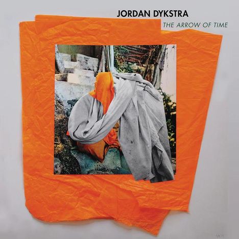 Oben stehen "JORDAN DYKSTRA" und "THE ARROW OF TIME". Ein farbiges Foto zeigt bunte Stoffe vor alten Treppen.