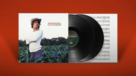"ARTHUR RUSSELL: Love Is Overtaking Me." Ein Mann steht in einem Feld, daneben eine Schallplatte.