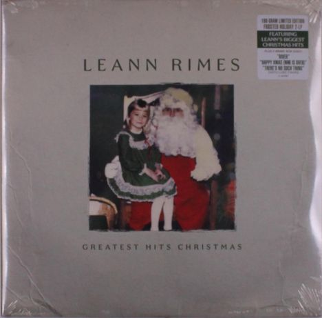 "LEANN RIMES", "GREATEST HITS CHRISTMAS". In der Mitte ein Kind in einem grünen Kleid mit Weihnachtsmann.