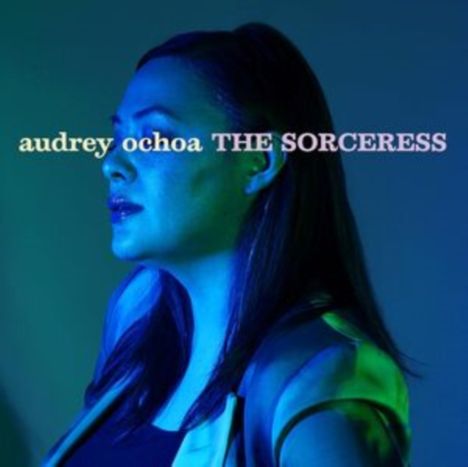 Text: "audrey ochoa THE SORCERESS". Eine Frau im Profil, in blau-grünes Licht getaucht.