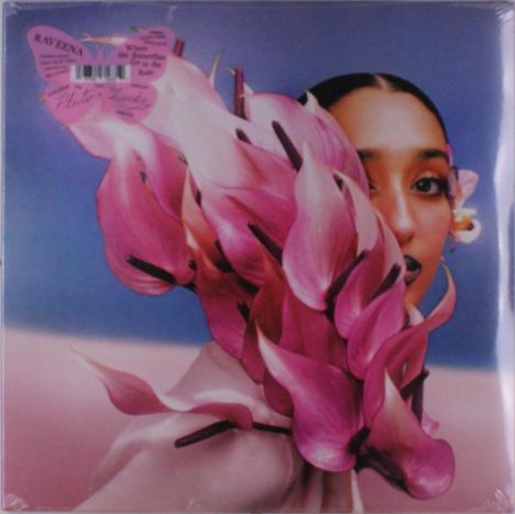 Zu sehen sind die Worte „Raveena“ und „Asha's Awakening“. Eine Frau mit rosa Blüten vor ihrem Gesicht.