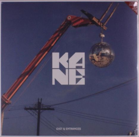 Text: "KANE EXIT & ENTRANCES". Ein Kran hält eine spiegelnde Kugel am Haken, über einer Stromleitung im blauen Himmel.