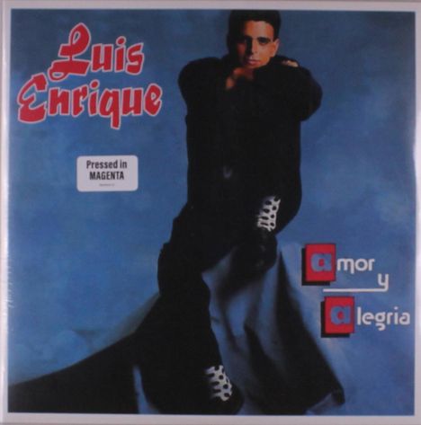 Text: "Luis Enrique", "Pressed in MAGENTA", "amor y alegría". Ein Mann mit dunkler Kleidung sitzt vor blauem Hintergrund.