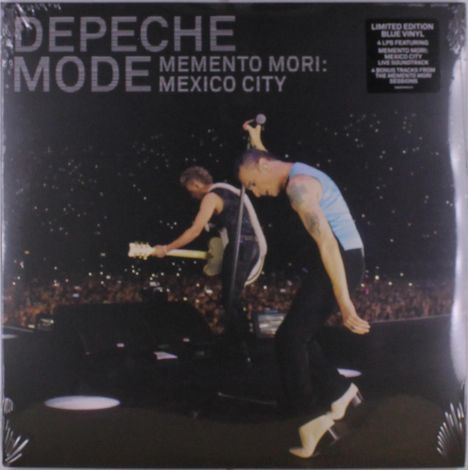 Aufschrift: "Depeche Mode Memento Mori: Mexico City". Zwei Musiker auf der Bühne vor großem Publikum.