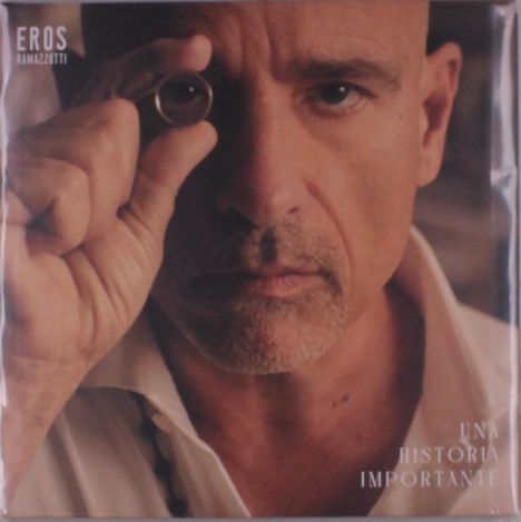 Aufschrift: "EROS RAMAZZOTTI" und "UNA HISTORIA IMPORTANTE". Ein Mann hält einen Ring ans Auge und schaut ernst.