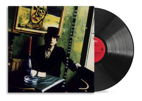 „BOB DYLAN World Gone Wrong“ ist schräg auf einem Cover abgebildet. Eine Schallplatte mit rotem Label ist teilweise sichtbar.