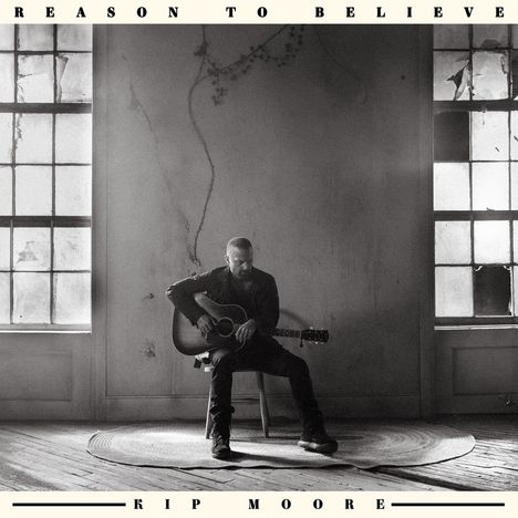 "Reason to Believe" oben, "Kip Moore" unten. Ein Mann sitzt mit Gitarre in einem leeren Raum zwischen zwei Fenstern.