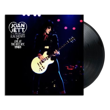 "JOAN JETT AND THE BLACKHEARTS LIVE AT THE RITZ NYC 1981." Frau spielt Gitarre auf einer Bühne in dunklem Ambiente.
