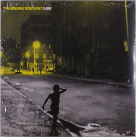 Text: "The Airborne Toxic Event Glory". Nachtansicht einer Straße, ein Kind im Vordergrund, dunkle Gebäude im Hintergrund.