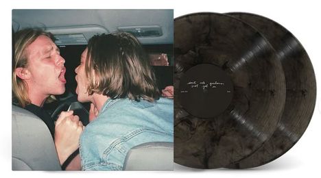 Zwei Schallplatten mit Text "smile and wave" vor einem Foto von zwei Menschen, die sich im Auto gegenüberstehen.