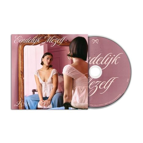 Text: "Eindelijk Mezelf" und "LUNA". Eine Frau sitzt vor einem Spiegel in einem Raum mit rosa Wänden und Holzrahmen.