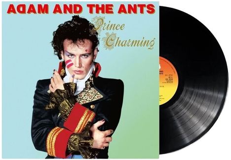 "ADAM AND THE ANTS" oben in Rot, "Prince Charming" in Gold. Person mit extravagantem Kostüm, auffälligem Make-up.