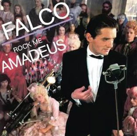 "FALCO ROCK ME AMADEUS" in weißer und roter Schrift. Eine Person im Anzug singt in ein Mikrofon vor einem Publikum in Kostümen.