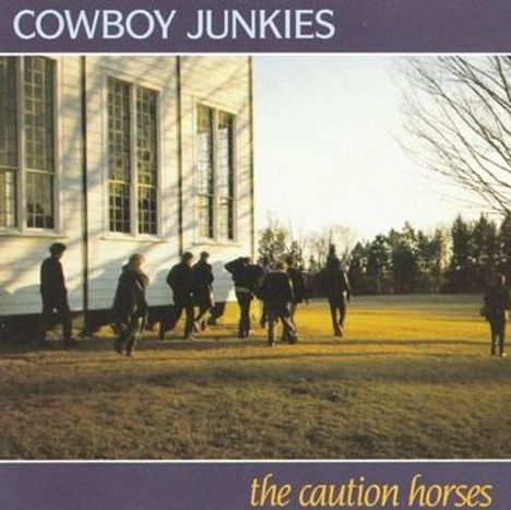 "COWBOY JUNKIES" oben, "the caution horses" unten. Menschen gehen in einer sonnigen Parklandschaft entlang eines Gebäudes.