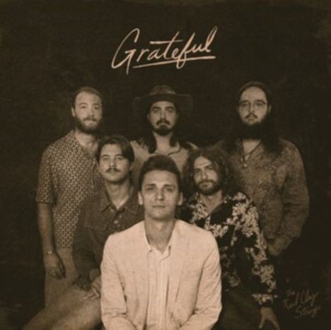 „Grateful“ steht oben. Sechs Männer mit Bart, teils mit Hut, teils in gemusterten Hemden, posieren zusammen.