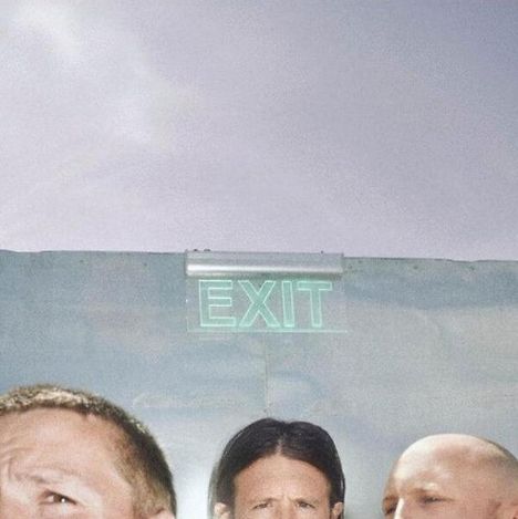 „EXIT“-Schild auf einer Wand, darunter sind die Köpfe von drei Personen teilweise sichtbar.