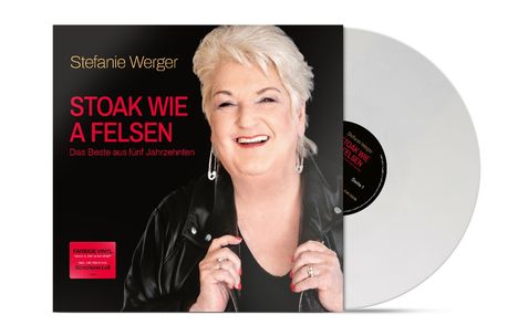 "Stefanie Werger. STOAK WIE A FELSEN. Das Beste aus fünf Jahrzehnten." Frau lächelt, hält Jacke. Vinyl-Schallplatte dabei.