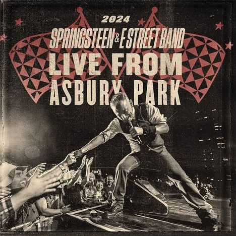 2024 Springsteen & E Street Band Live from Asbury Park. Ein Sänger kniet auf der Bühne und reicht Fans die Hand.