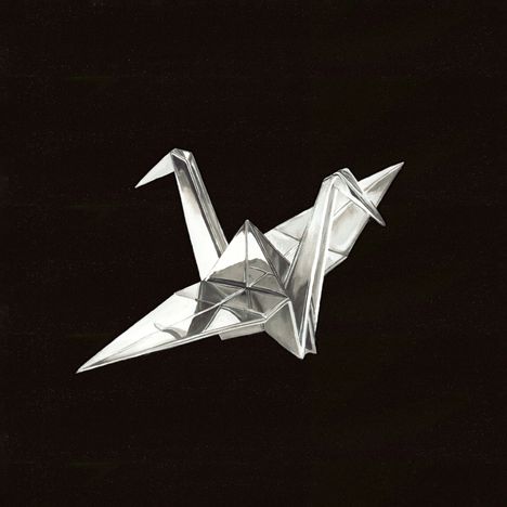 Eine Origami-Kranichskulptur in Silber auf schwarzem Hintergrund. Keine sichtbaren Texte.