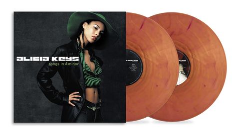 Text: "Alicia Keys, songs in A minor". Frau in Lederjacke, Hut, grün gestreiftem Oberteil, Hand in Hüfte.