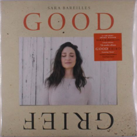Text: "Sara Bareilles, Good, Grief." Eine Frau mit langen Haaren steht vor einer Holzwand und hat die Augen geschlossen.