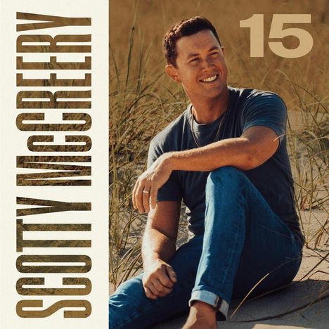"SCOTTY McCREERY" steht links senkrecht, große "15" oben rechts. Ein Mann sitzt lächelnd in Grasdünen.