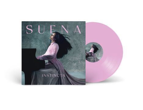 SUENA; INSTINCTA. Eine Frau in einem rosa Kleid spielt Klavier mit leidenschaftlichem Ausdruck.