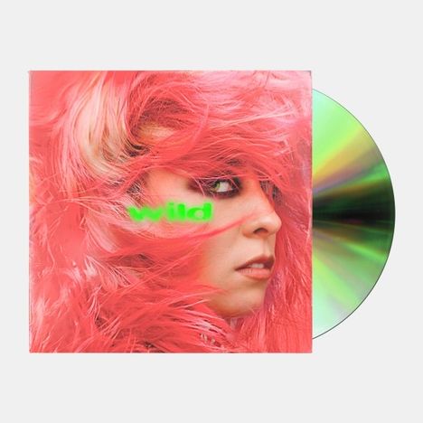 Text "wild" in grün auf einem Cover mit rosafarbenem Haar, das ein Gesicht umrahmt. Rechts daneben eine schimmernde CD.