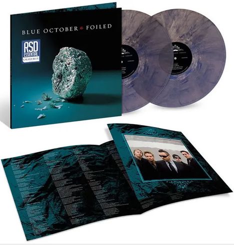 Text: "BLUE OCTOBER FOILED". Eine silberne, zerknitterte Kugel ähnlich Alufolie liegt auf einer glatten Oberfläche.