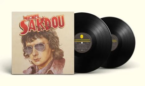 "Michel Sardou" in großen Buchstaben auf einem Albumcover mit einem Porträt eines Mannes und zwei schwarzen Schallplatten.