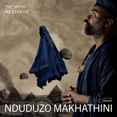 Texte: "THE MYTH WE CHOOSE", "NDUDUZO MAKHATHINI". Eine Person in blauem Gewand blickt nach oben, pyramidenartige Strukturen im Hintergrund.