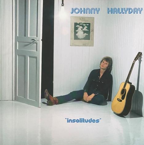 Text: „JOHNNY HALLYDAY insolitudes“. Ein Mann sitzt in einem weißen Raum, eine Gitarre steht daneben.