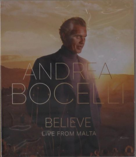 Text: "ANDREA BOCELLI BELIEVE LIVE FROM MALTA." Ein Mann im Anzug vor einem Sonnenuntergang in einer Landschaft.