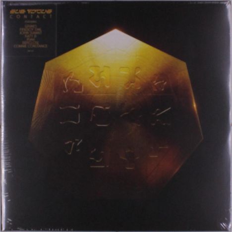 Text oben: SUB FOCUS CONTACT. Ein goldenes, oktagonales Objekt mit eingravierten Symbolen, beleuchtet im Dunkeln.