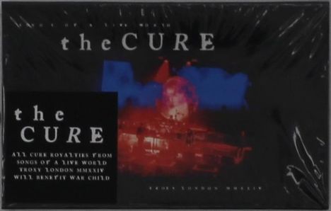 "The Cure" und Info zu Royalties für War Child. Unscharfes Bild mit blauen und roten Lichtreflexen im Hintergrund.