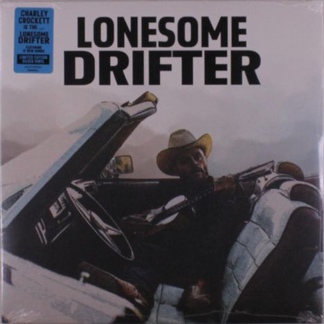 "LONESOME DRIFTER" ist groß geschrieben. Ein Mann mit Cowboyhut sitzt in einem Auto und hält eine Gitarre.