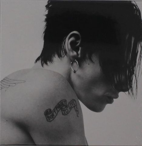 Text: "Don't forget to live" auf einem Band. Schwarz-Weiß-Fotografie eines Mannes mit kurzem Haar und Ohrring, zeigt den Rücken.